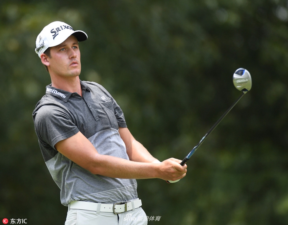 赛事观众聚集在TPC南风球场第18洞果岭周围，屏息凝神地观看球员处理关键推杆。