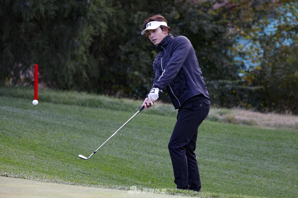 张哲瀚在球道边进行赛前热身，他伸展手臂，转动腰胯，为即将开始的比赛充分激活身体机能，神情轻松而投入。