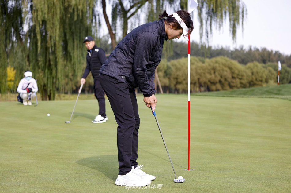 张哲瀚的切杆动作瞬间抓拍，球杆划过空中，动作舒展而有力，脚下的草屑微微扬起，定格下力量与技巧完美结合的一刻。