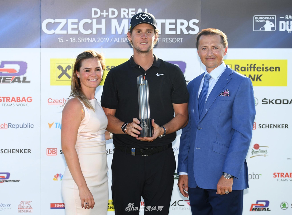 冠军皮特斯面向观众张开双臂，享受全场欢呼，背后是信天翁度假村的壮丽风景