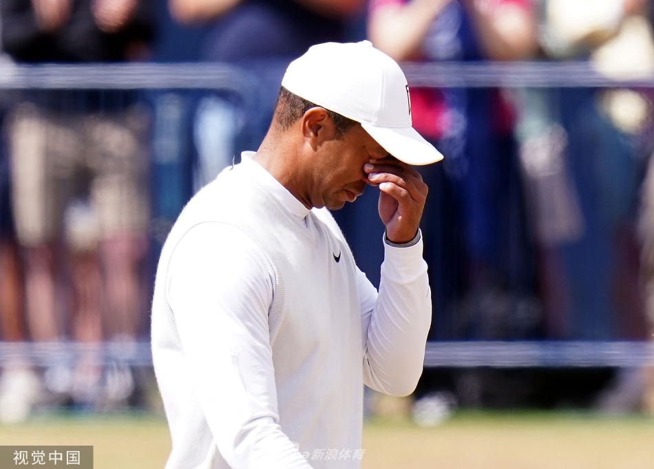 伍兹完成推杆后，与同组球手及球童握手，他们脸上都带着尊敬的笑容，背景中的皇家古老高尔夫俱乐部会所静静矗立