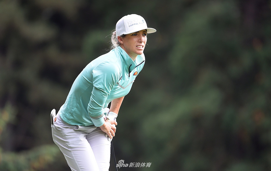 汉纳-格林在球道中优雅挥杆，金色长发在微风中划出动人弧线