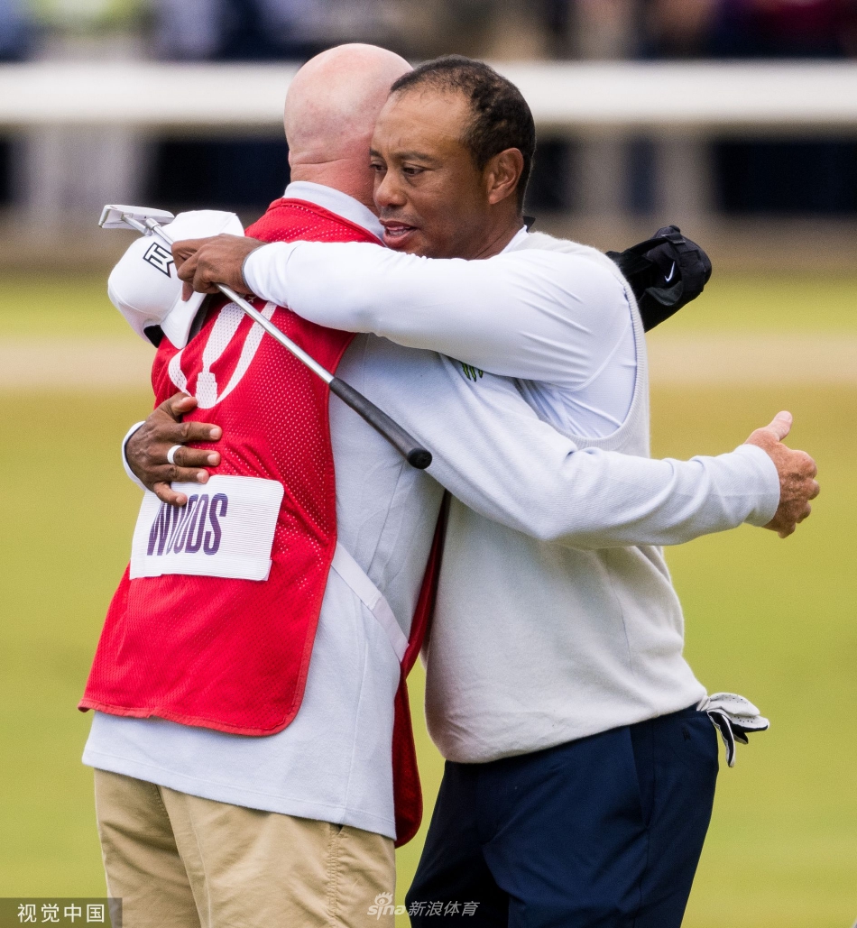 伍兹背对镜头走向果岭，红色POLO衫的背影在广阔的绿茵与灰蓝天空下显得孤独而坚定，宛如一幅充满故事的油画
