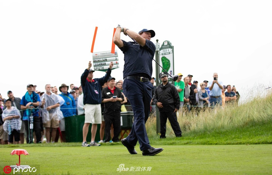 比赛进行时天空乌云密布，一名球童为球员撑起雨伞，展现了高尔夫运动在风雨中坚持竞技的独特魅力与挑战。