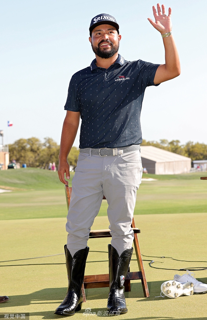 斯鲍在球道上全神贯注地准备击球，阳光勾勒出他专注的侧影，手中的铁杆蓄势待发，背景是典型的德州橡树林立的风光。