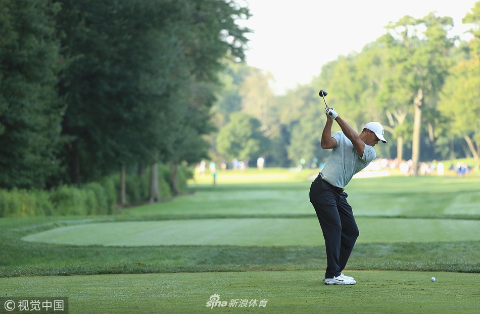 伍兹在比赛中与球童认真商讨下一杆的策略,神情专注。