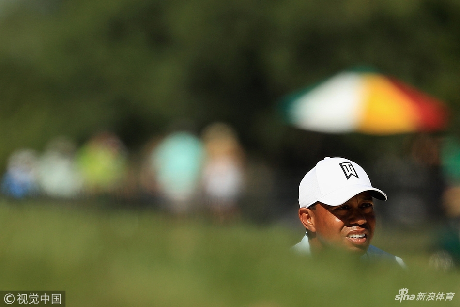 伍兹从果岭边沙坑中成功救球后，向观众致意，沙坑的陡壁见证了这一记精彩的技术击球。