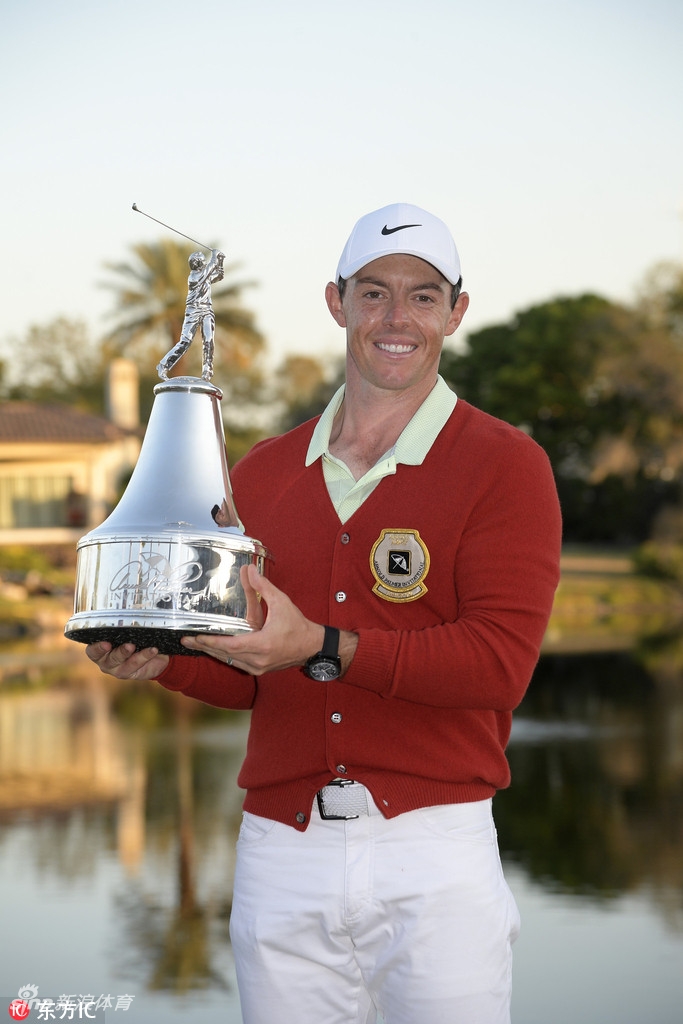 麦克罗伊穿上象征胜利的红色冠军夹克，笑容灿烂，与奖杯合影