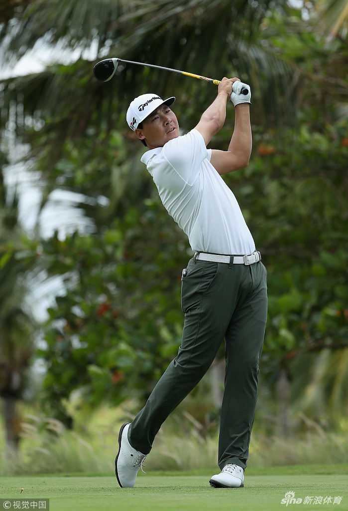 张新军与球童在果岭边蹲身认真研读推杆线路，进行关键决策