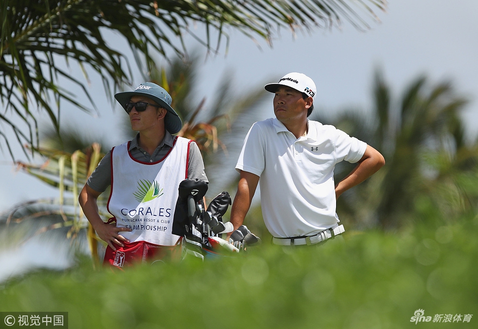 张新军在多米尼加大风中凝神准备击球，目光坚定地望向前方的果岭