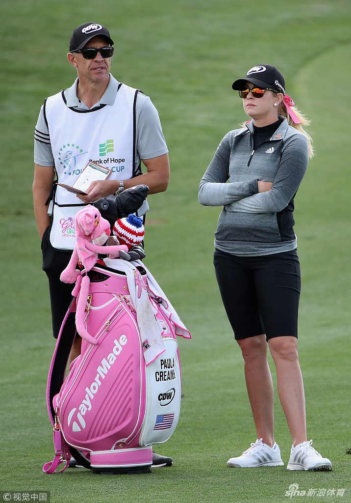 赛事观众聚集在果岭周围,全神贯注地观看球员推杆,现场气氛紧张而热烈。