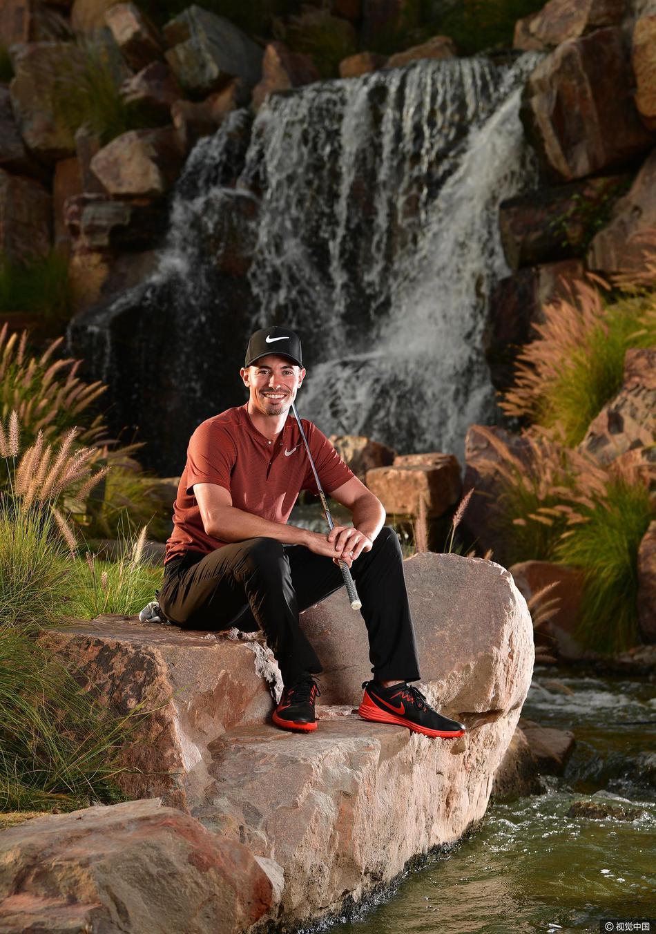 观众稀疏的看台上,一位球手孤独而坚定地走向下一个发球台,身影尽显职业运动员的征程感。