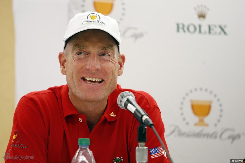 美国队队长史蒂夫·史翠克在发布会上发言，神情专注，面前摆放着象征荣誉的总统杯奖杯模型