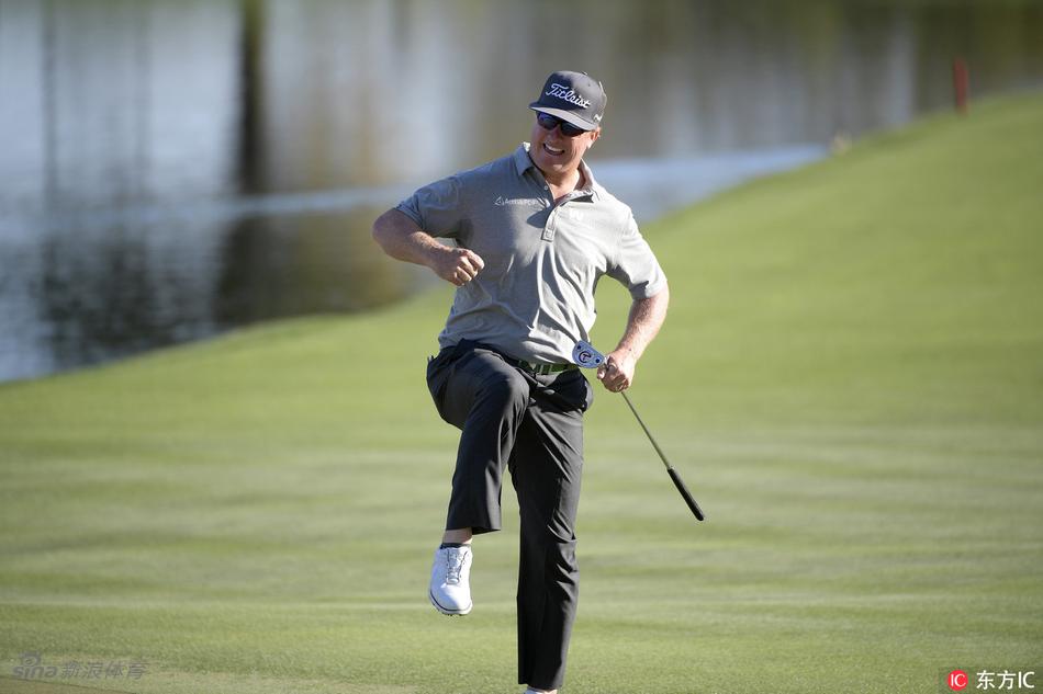 韩国球员王情训与他的球童站在球道边，球童身材魁梧，两人正专注地讨论着下一杆的策略选择。