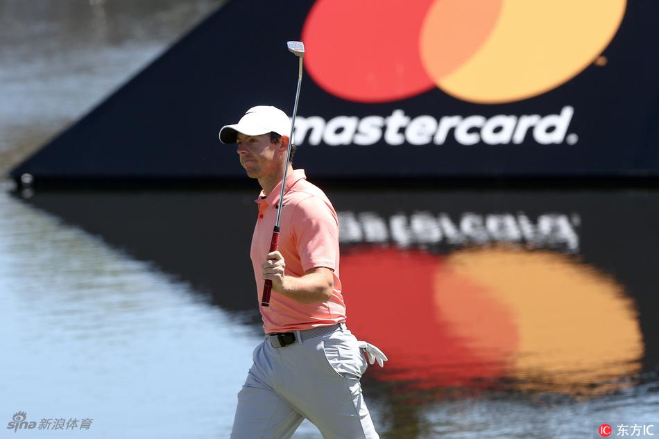 罗里·麦克罗伊在湾丘球场的关键沙坑中，身体微微扭转，眼神专注地完成一次高难度救球。