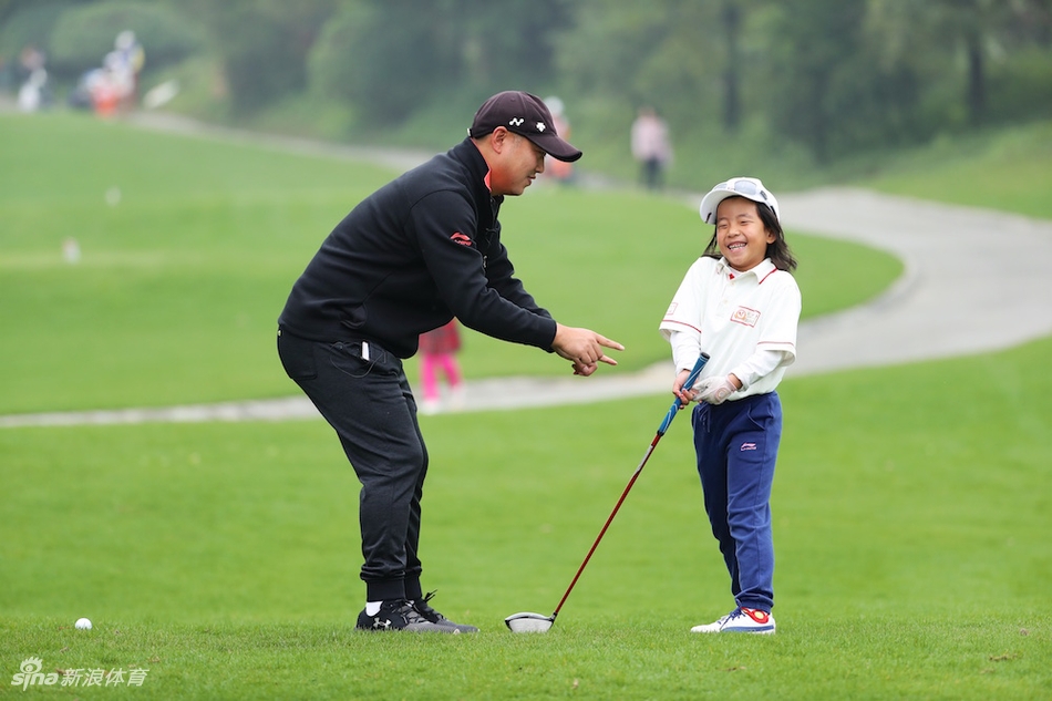刘宇婕凝神准备击球，父亲刘国梁在一旁静静守候观察