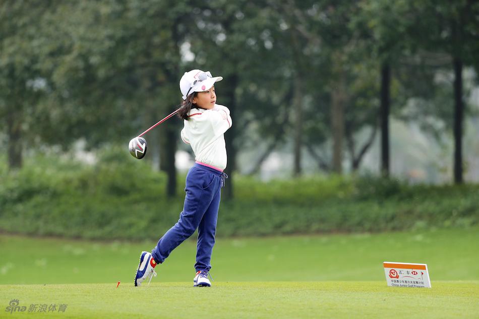 刘国梁弯腰专注地指导女儿刘宇婕推杆动作，目光如炬