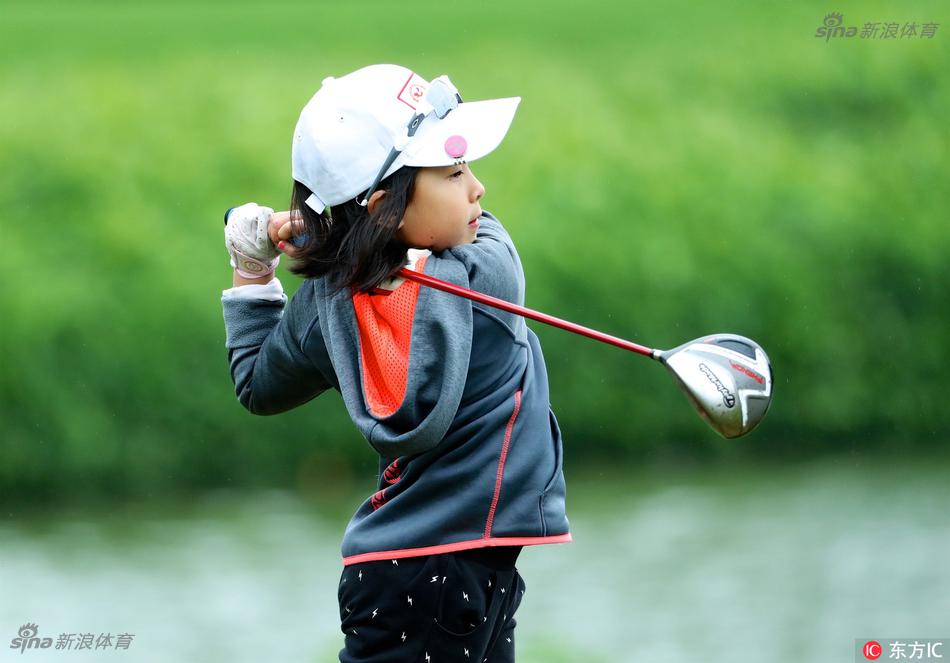 冠军家庭的全家福：刘国梁一家四口身着运动装，在草地上笑容灿烂，温馨有爱的氛围溢出画面。