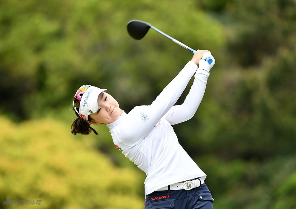 石昱婷完成收杆动作后身姿挺拔，目光追随着空中飞行的小球，背景是蔚蓝辽阔的太平洋