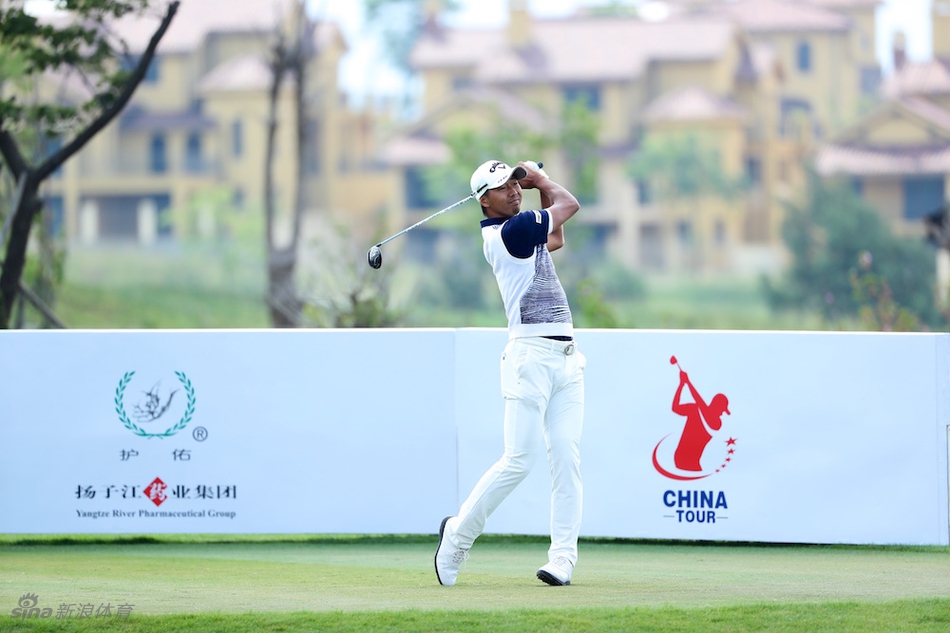 球手在比赛中挥杆击球，阳光勾勒出矫健身影，背景是开阔的球场