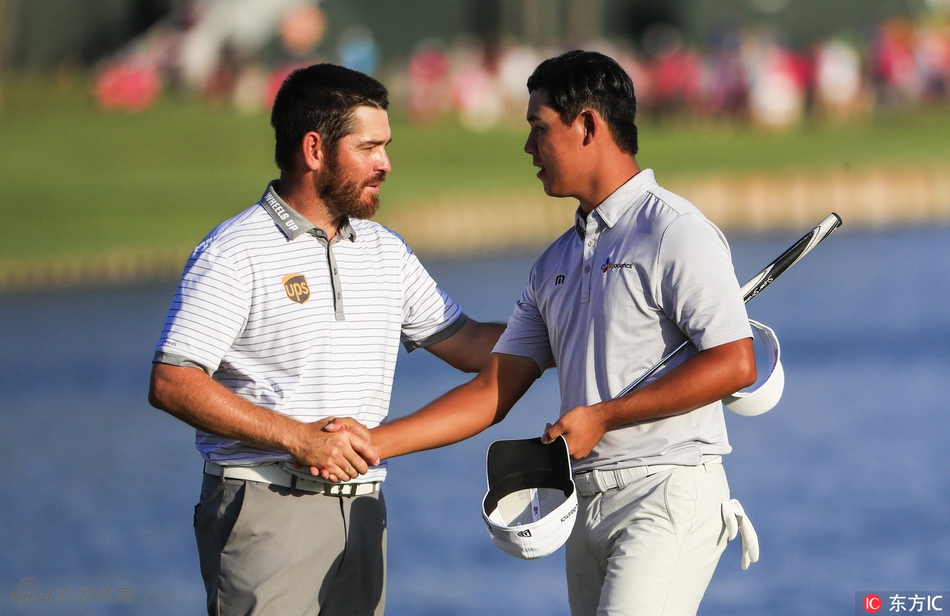 卫冕冠军简森·戴伊微笑着将沉甸甸的水晶奖杯递交给新科冠军金时沅