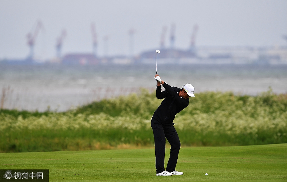 李昊桐在果岭上屈膝观察推杆线路,凝神思考