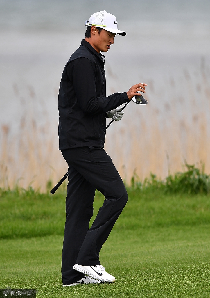 李昊桐在开球前细致擦拭杆头,神情专注而平静