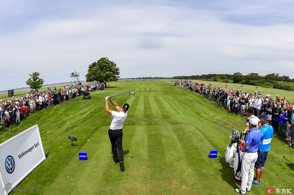 克里斯·伍德在发球台上大力开球，身体充分扭转，白色小球划破天际，充满力量感。