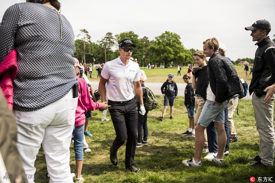观众聚集在果岭周围，屏息凝神观看关键推杆，现场紧张而专注的氛围扑面而来。