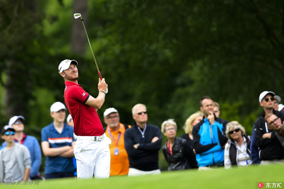 夕阳余晖下，一位球员在球道中远眺果岭，金色阳光洒满赛场，画面静谧而充满期待。