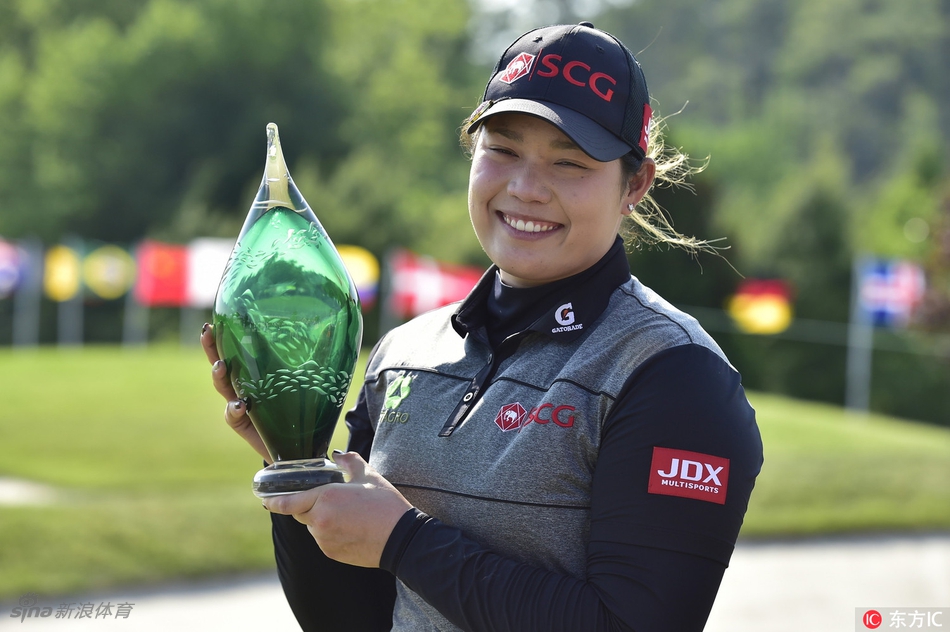 阿瑞雅在果岭边专注观察推杆线路，眼神坚毅而冷静，冠军的专注力在那一刻凝聚。