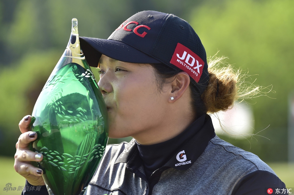 阿瑞雅完成标志性的收杆动作，身体平衡而舒展，仿佛一尊胜利者的雕塑，定格于蓝天绿草之间。