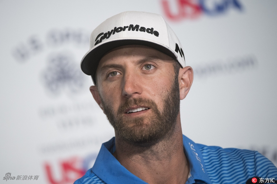 达斯汀在练习果岭边与球童细致交流，两人正针对复杂的果岭坡度与草纹研究推杆线路。