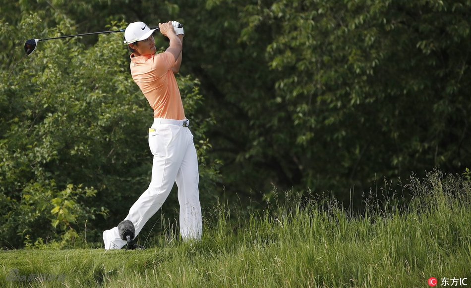 李昊桐在果岭边凝神观察推杆线路,指尖轻触草叶感知坡度