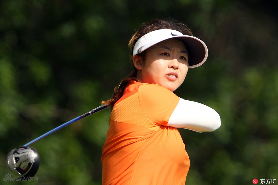 果岭上的深思：冯思敏与球童一同俯身察看推杆线路，神情专注