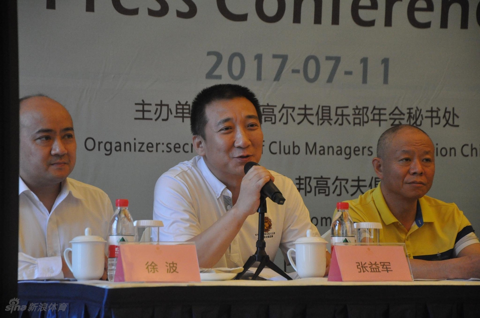 一位企业高管正在认真回答记者提问,表情专注,面前摆满了录音设备