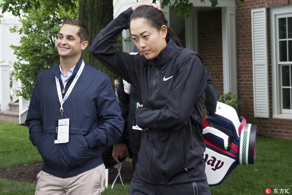 冯珊珊在果岭上弯腰仔细阅读草纹走向,阳光洒在她专注的脸庞上