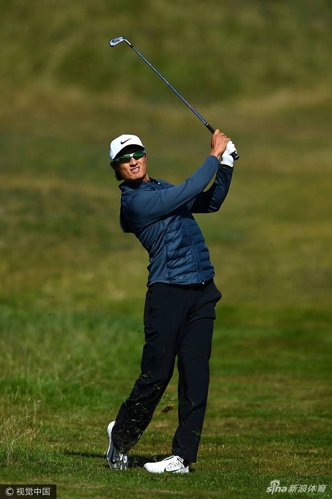 李昊桐在全神贯注地推击，身旁的球童和观众都在静静等待