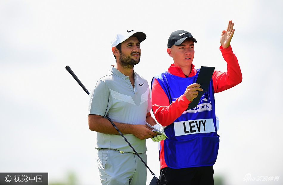 列维与身旁的球童进行战术交流共同商讨下一杆的策略