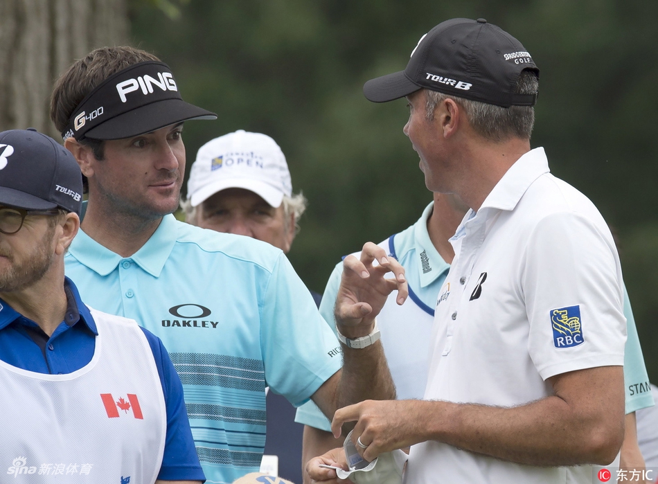 巴巴·沃森与马特·库查尔同组行走在球道上，两人神情专注，仿佛在雨中交流着战术。