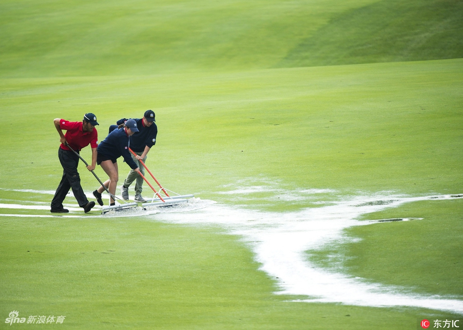工作人员正紧急为果岭覆盖防雨罩，绿色篷布在灰暗天空下显得格外醒目，保障着比赛的公平进行。