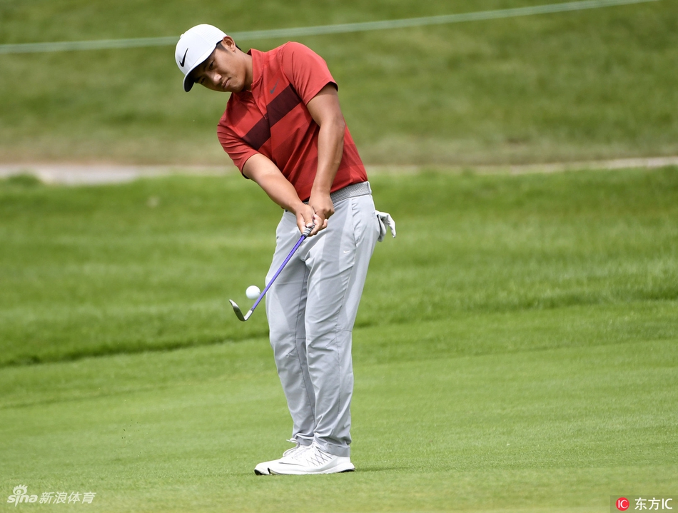 潘政琮弯腰仔细观察果岭推杆线路,神情专注研究草纹与坡度