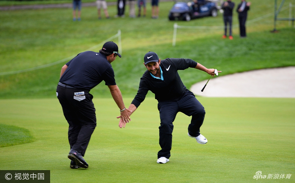 球员在沙坑中救球，沙砾飞溅，捕捉到高尔夫比赛中力量与技巧结合的瞬间