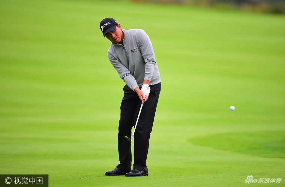 卫冕冠军亚历山大·列维在果岭上仔细阅读推杆线路，眼神专注，身后是广袤的球场与阴沉的天空