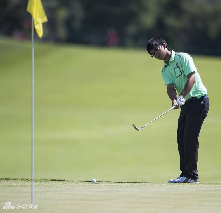 窦泽成面带微笑手扶奖杯，与身后英文名标语合影留念