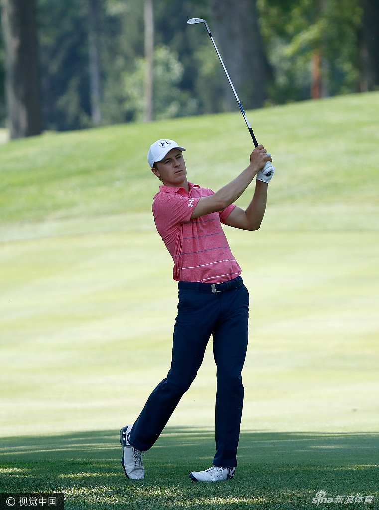 斯皮思与球童在练习果岭边弯腰仔细观察地形，两人身影构成默契搭档，共同剖析赛场每一处细节。