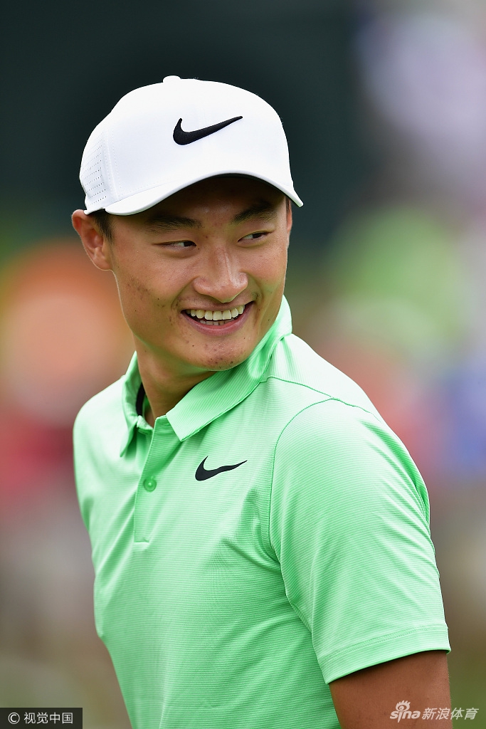 李昊桐在果岭上弯腰轻推，白色小球沿着预定线路精准滚向洞杯