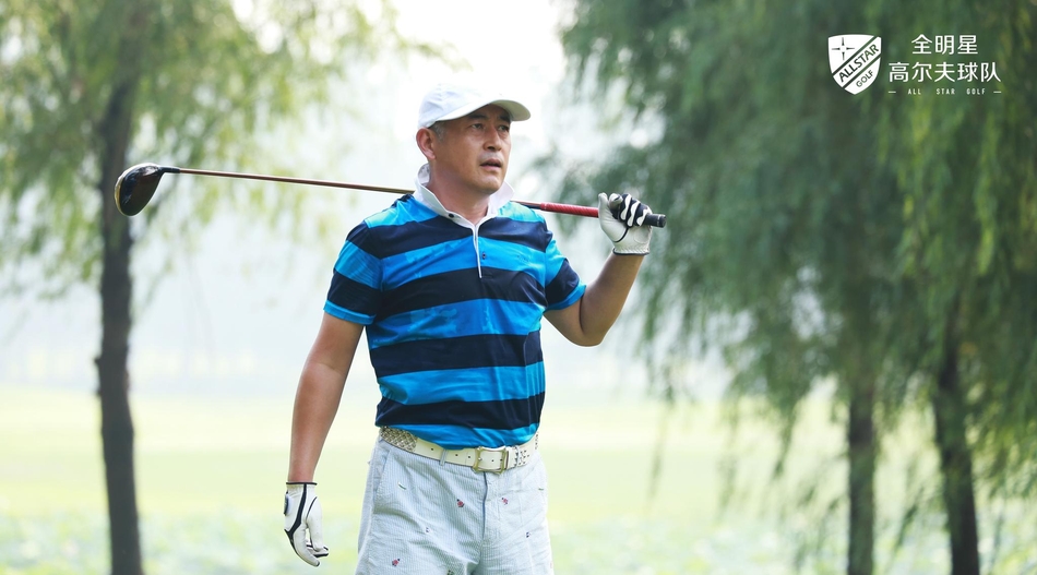 葛优与友人在赛场边开怀大笑，表情生动自然，尽显赛场下的轻松与惬意