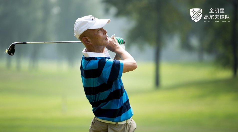 葛优侧身凝神，以标志性的放松姿态挥杆，球杆在空中划出一道潇洒弧线，绿草如茵的背景衬托出他独特的诙谐与专注