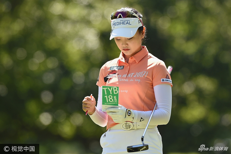 石昱婷在球道中认真查看码数本，精心计算下一杆的击球策略